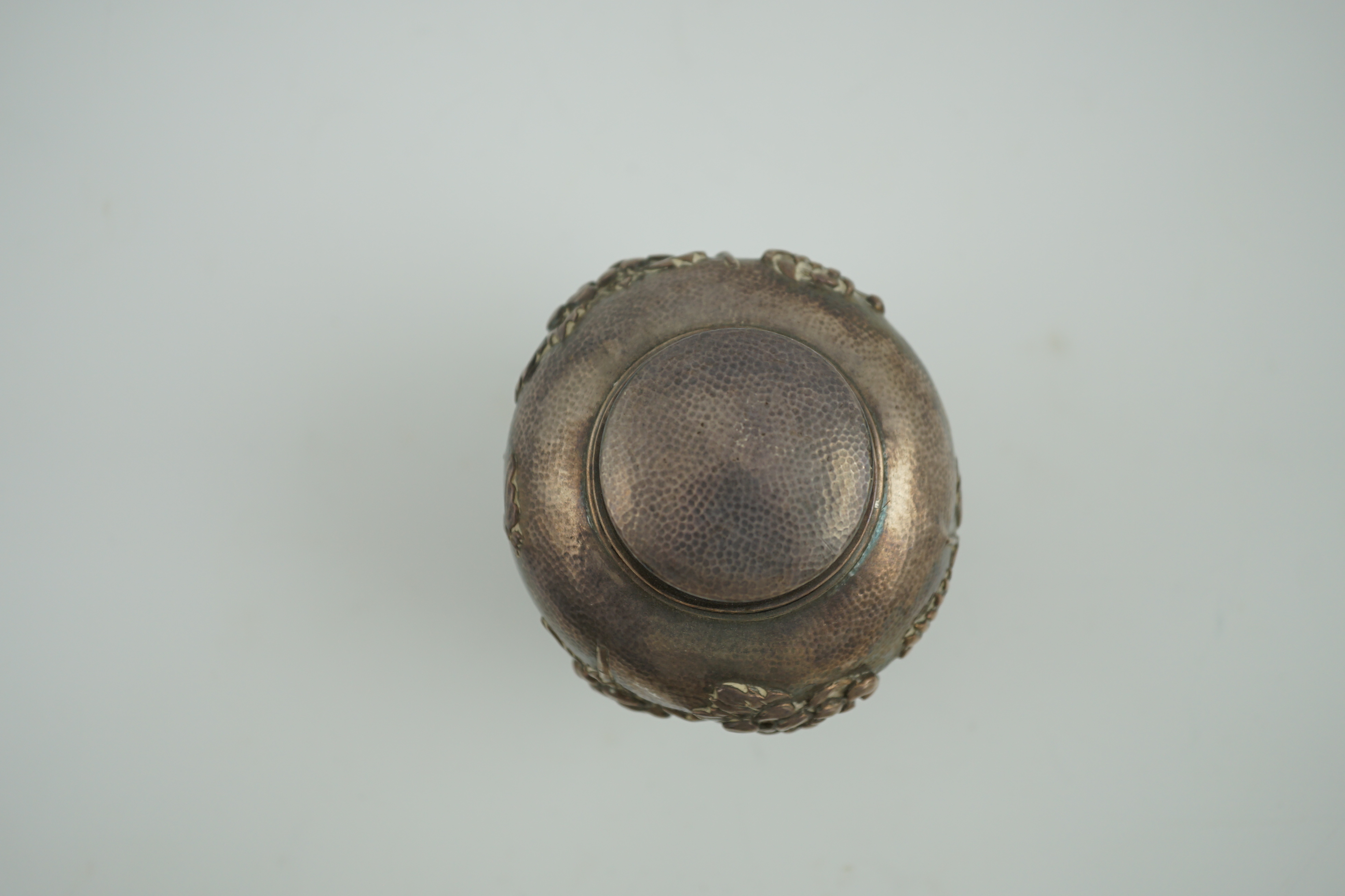 An early 20th century Japanese silver ovoid tea caddy and cover, decorated with prunus, together with a similar Japanese silver bowl